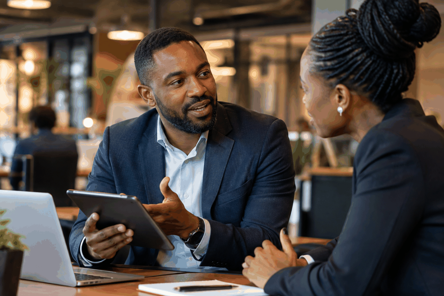 Professionals Discussing Commercial Data on Tablet in Office